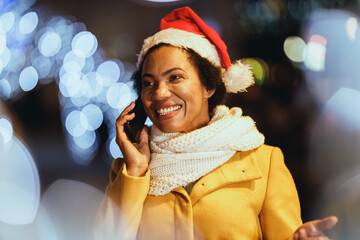 Wall Mural - Black Woman Using Smartphone In The City At Christmas Time