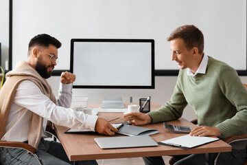 Wall Mural - Male bank manager working with his colleague at table in office