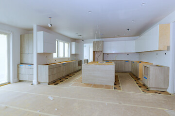 Wall Mural - The installation of white kitchen cabinets in newly constructed house