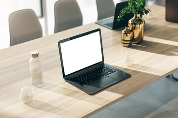 Aufkleber - Perspective view on modern black laptop with blank white screen with space for your logo or text on wooden table with glass of water and golden vases in sunlit office. 3D rendering, mock up