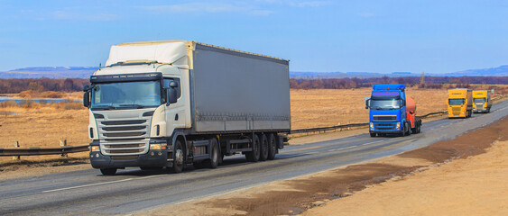 Wall Mural - line of trucks moving on road