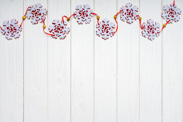  Christmas background with red felt snowflakes garland on white wooden background. Top view, flat lay with copy space, banner, header, New Year background