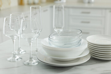 Sticker - Different clean dishware and glasses on white marble table in kitchen