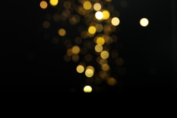 Wall Mural - blurred view of golden lights on black background. bokeh effect