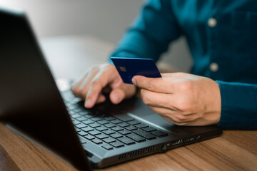 Poster - Man uses a laptop to register through a credit card to make online purchases. Credit card safe online shopping and payment concept.