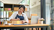 © bongkarn - Asian female small online business owner writing customer's address on a cardboard box