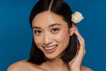 Wall Mural - Portrait of young beautiful smiling asian woman with flower