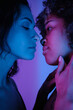© Clique Images - Vertical close-up studio shot of young lesbian Black and Caucasian women standing in front of each other going to kiss