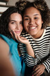 © Clique Images - Vertical medium close-up portrait of ethnically diverse young women in love taking selfie photo