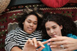 © Clique Images - Top-down close-up portrait of attractive young women in love relaxing on floor close to each other having tender skinship