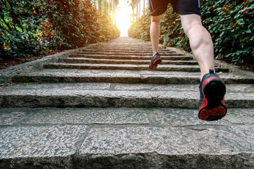 Wall Mural - Low section of runner athlete running on staircase