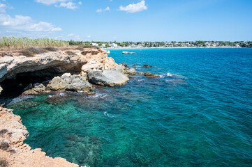 beautiful cave with clear and crystalline turquoise water in Sicily in Syracuse with the beach of Fontane Bianche in the background