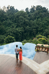 Wall Mural - Young couple standing by a swimming pool