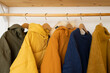 © Lys Owl - Warm jackets and knitted sweaters hang on wooden hangers in the room