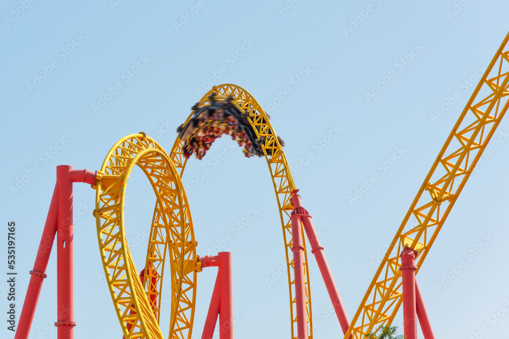 Amusement cart makes circular loops upside down at motion blur effect high speed, roller coaster.
