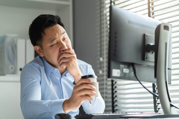 Wall Mural - Exhausted Asain business man using laptop computer working in office.