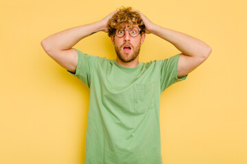 Wall Mural - Young caucasian man isolated on yellow background surprised and shocked.