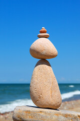 Wall Mural - Rock zen pyramid of white stones on the beach