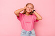 © Asier - Caucasian teen girl isolated on pink background covering ears with hands.