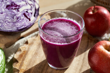 Sticker - A glass of purple cabbage juice with a head of red cabbage and apples