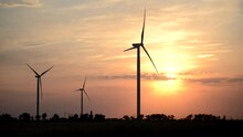 Video Of Wind Power Station Of Giant Windmills In Works Under Red Sky At Sunset
