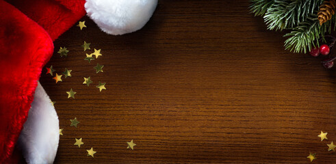 Wall Mural - christmas banner. christmas tree branch and santa hat on wooden background. wide xmas banner mockup,