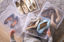 Female Hands Pack Shoes On Heels Into Plastic Box Home Wardrobe Storage Method Organization Top View