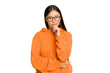 © Asier - Young Asian woman isolated on green chroma background suspicious, uncertain, examining you.