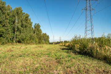 Wall Mural - Power line towers. Out-of-town power supply system. Energy infrastructure in the fields in the countryside.