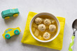 meatballs soup for children in white bowl on grey table. Childrens menu. closeup, copy space