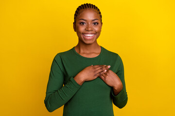 Wall Mural - Photo of excited dreamy young woman wear green shirt arm chest smiling isolated yellow color background