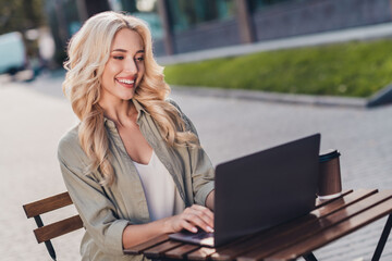 Poster - Portrait of attractive focused cheerful wavy haired girl using netbook copywrite creative design in complex outdoors