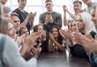 © ASDF - group of young diverse people applauding sitting at the same table.
