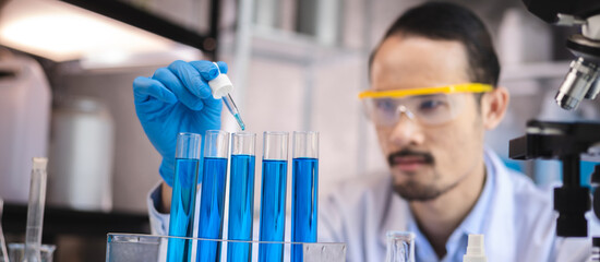 blue chemical liquid experiment in scientific glassware equipment in science medicine laboratory, chemistry or biology research discovery by using glass of test tube or beaker and flask