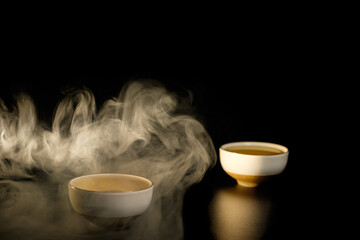 Two cups of chinese tea  with steam isolated on black background. Top view