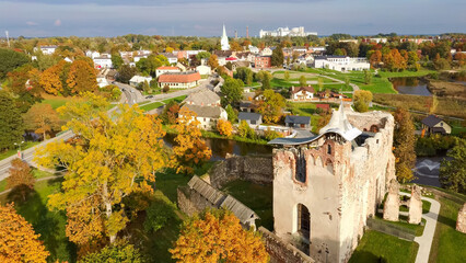 Wall Mural - Ruins of an Ancient Medieval Castle Dobele Latvia, Aerial Top View. Aerial Panorama of Dobele City, in the Foreground River With Fontains and Medieval Castle Ruins With Restored Castle Capella, Latvia