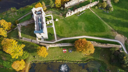 Wall Mural - Ruins of an Ancient Medieval Castle Dobele Latvia, Aerial Top View. Aerial Panorama of Dobele City, in the Foreground River With Fontains and Medieval Castle Ruins With Restored Castle Capella, Latvia