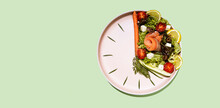 Intermittent Fasting Concept Plate As A Clock With Salad, Salmon, Fish And Vegetables, Tomato, Lemon