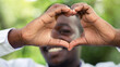 © arrowsmith2 - Close-up portrait of african man showing heart symbol sign looking camera
