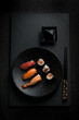 mix sashmi and sushi with chopstick over black stone
