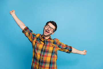 Wall Mural - Photo of peaceful handsome man in eyewear dressed checkered shirt stretching slumbering closed eyes isolated on blue color background