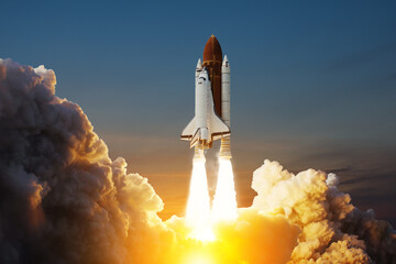 Spaceship lift off. Space shuttle with smoke and blast takes off into space on a background of sunset. Successful start of a space mission. Elements of this image furnished by NASA.