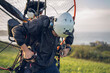 © lorenzophotoprojects - Young man, wearing a white helmet with an Action Cam on it, gets ready to fly with the Powered Paragliding ( PPG ) , and fastens his belt. In the background the Ocean.
