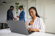 © Alexandr - successful young woman in the office with a laptop with a hand gesture on the background of people
