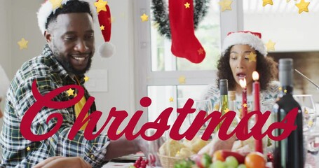 Sticker - Animation of christmas text over african american family having dinner