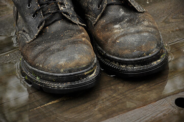 Pair of old boots on wooden floor boards