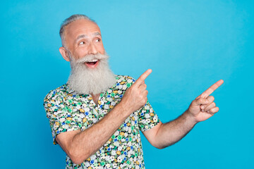 Poster - Photo of funny dreamy man pensioner dressed flower print shirt pointing two fingers looking empty space isolated blue color background