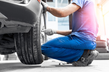 Wall Mural - Concept banner service car wheel, changing sport summer tire on machine at station with sunlight