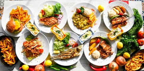 Delicious meat kebab with fresh vegetable salad served with variety of Turkish dishes and appetizers. Top view of assorted Turkish food and meze, tasty and healthy Mediterranean cuisine.