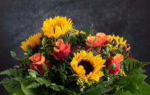 Close-up Of A Colorful Fresh Bouquet Of Roses And Sunflowers, Against A Gray Background